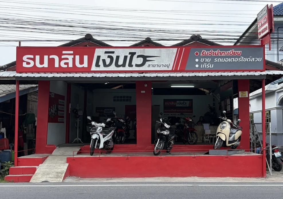หน้าร้านธนาสินเงินไว สาขาบางปู ป้ายร้านสีแดง มีมอเตอร์ไซค์มือสองจอดเรียงหน้าร้าน
